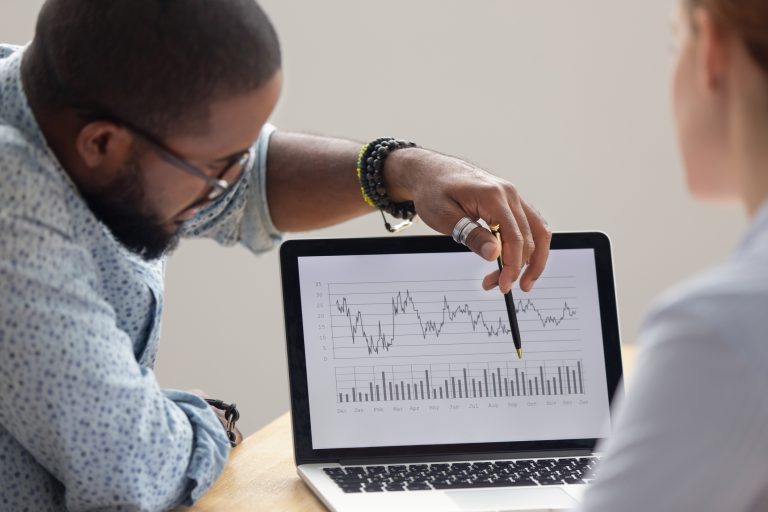 Focused african analyst showing annual financial report on laptop screen