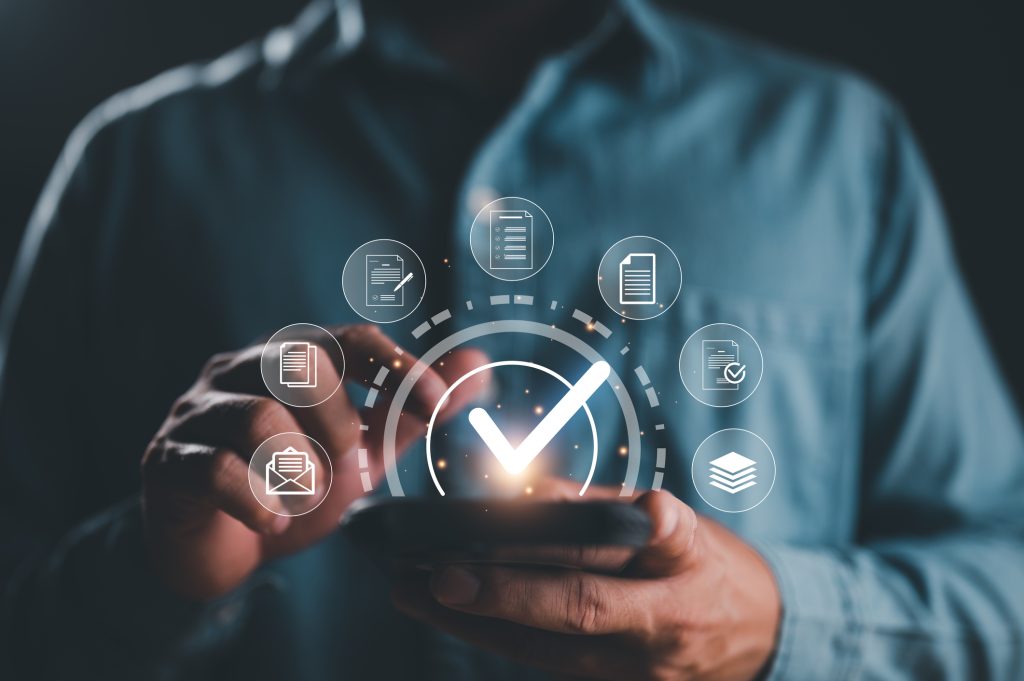 Service guarantee, Validation concept for business process automation, quality assurance management, certification, digital transformation. Businessman touching checked icon on virtual screen.